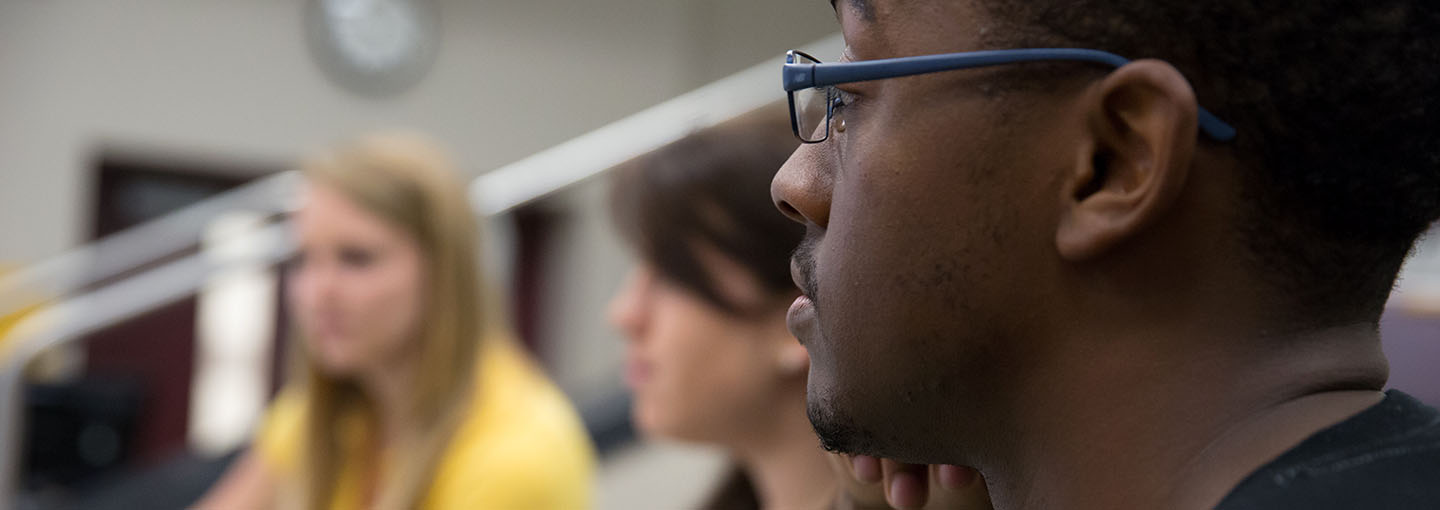 Side view of student with glasses in class