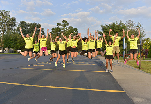 Orientation leaders jump in the air in unison.